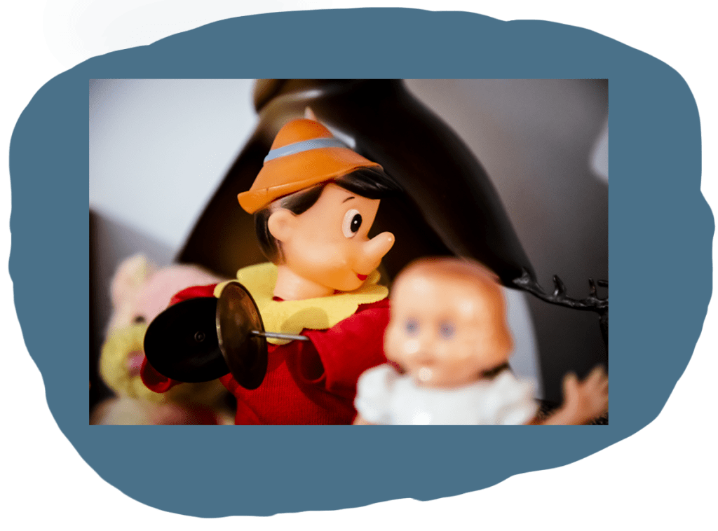 Pinocchio figurine with tambourines sitting on top of a shelf with toys.